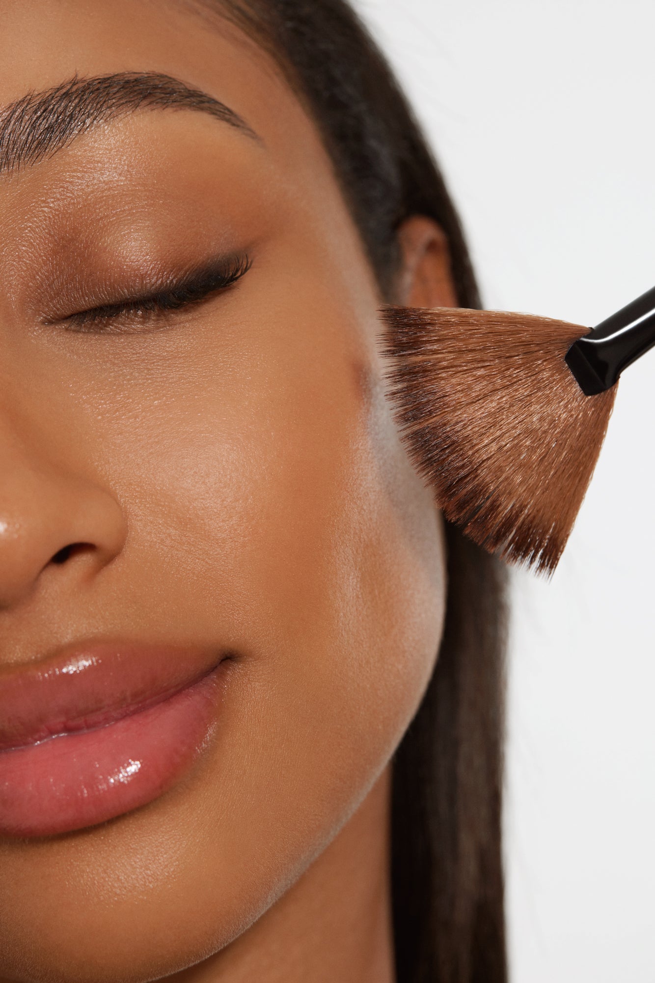 Close-up of a woman's face with a facial care brush, showcasing a professional facial treatment offered at the skincare clinic.