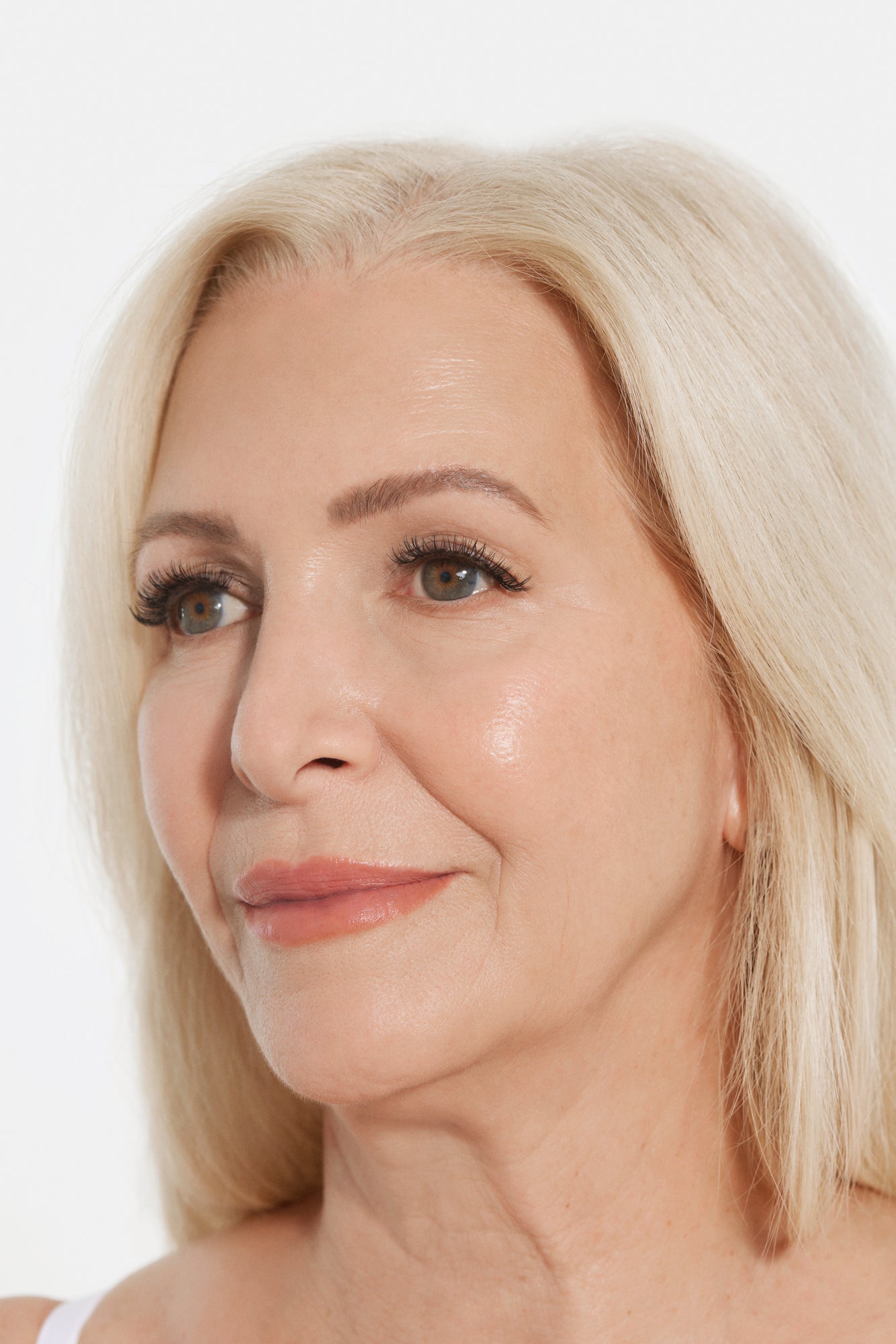 Close-up of a mature woman's face with rejuvenated skin and minimal wrinkles after advanced facial care treatment.