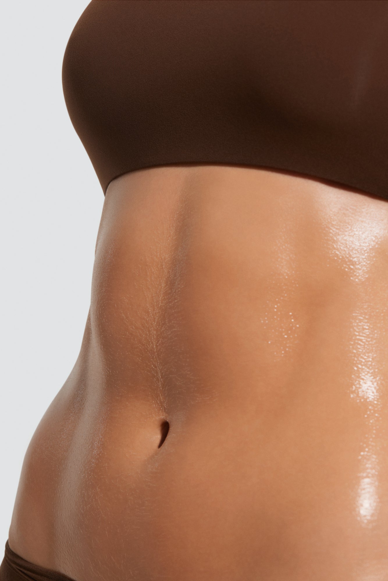 Close-up of a woman's belly with defined abs and firm, smooth skin after body care treatment for toned abdomen.